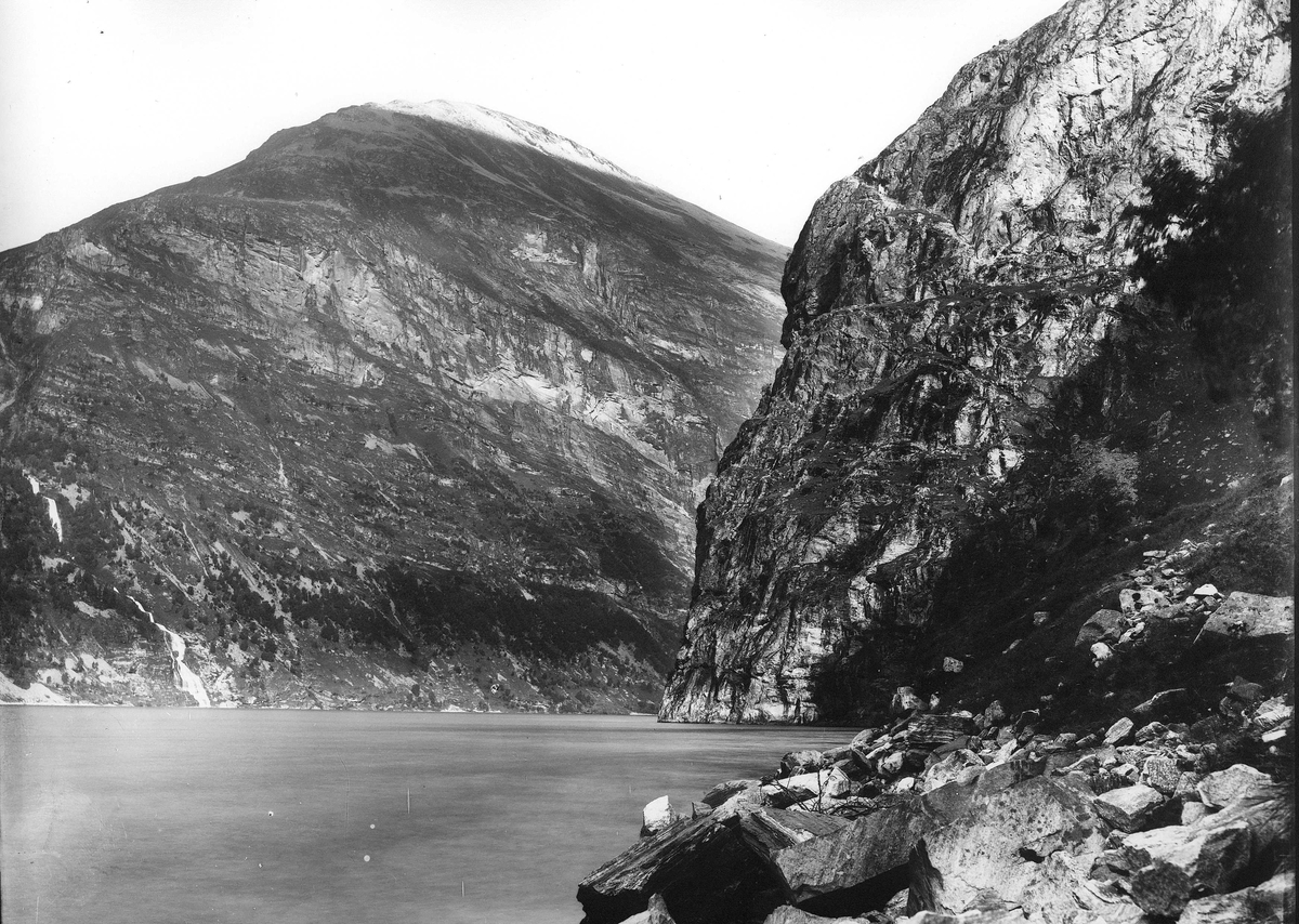 Landskap, ukjent sted. Bratte fjellpartier  går rett ned i fjord. Del av Den Norske Turistforenings samling landskapsbilder, de fleste tatt av fotografene Brødrene Brunskow.