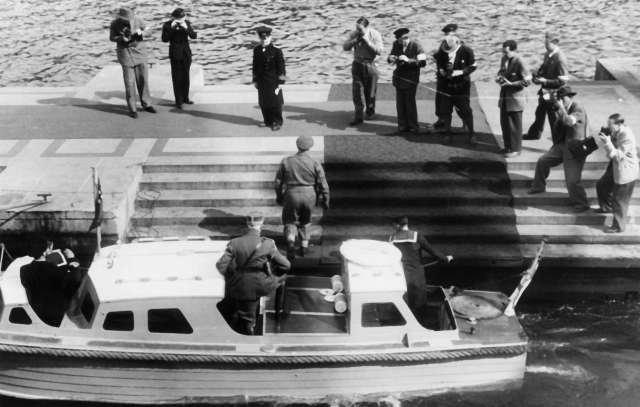 Fra Oslo under fredsdagene i 1945.
Den 13.mai kommer Kronprins Olav tilbake.Her stiger han i land på Honnørbrygga klokken 16.30, , i spissen for befal fra 
Forsvarets Overkommando. Begivenheten. blir behørlig fotografert. 