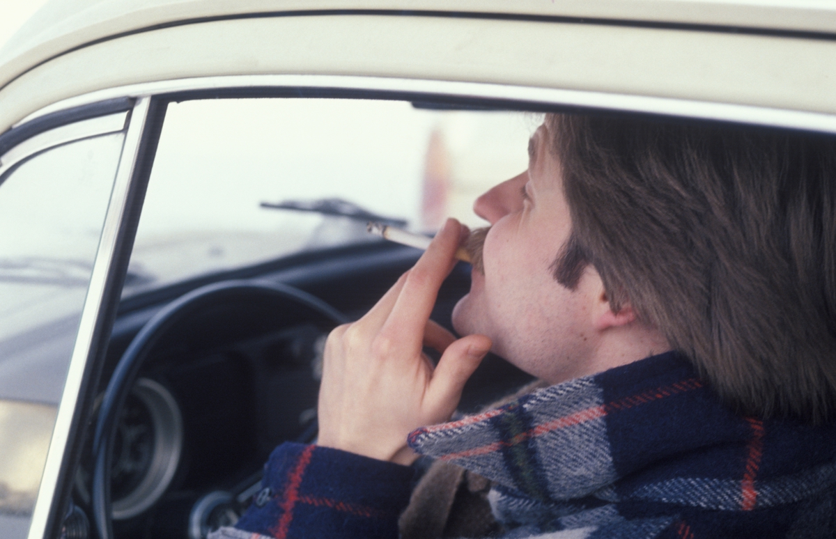 Reklamefoto av en mann som tar seg en røyk inni en bil. Reklamefoto fra presentasjon i forbindelse med introduksjon av Prince Mild i Norge i 1979.