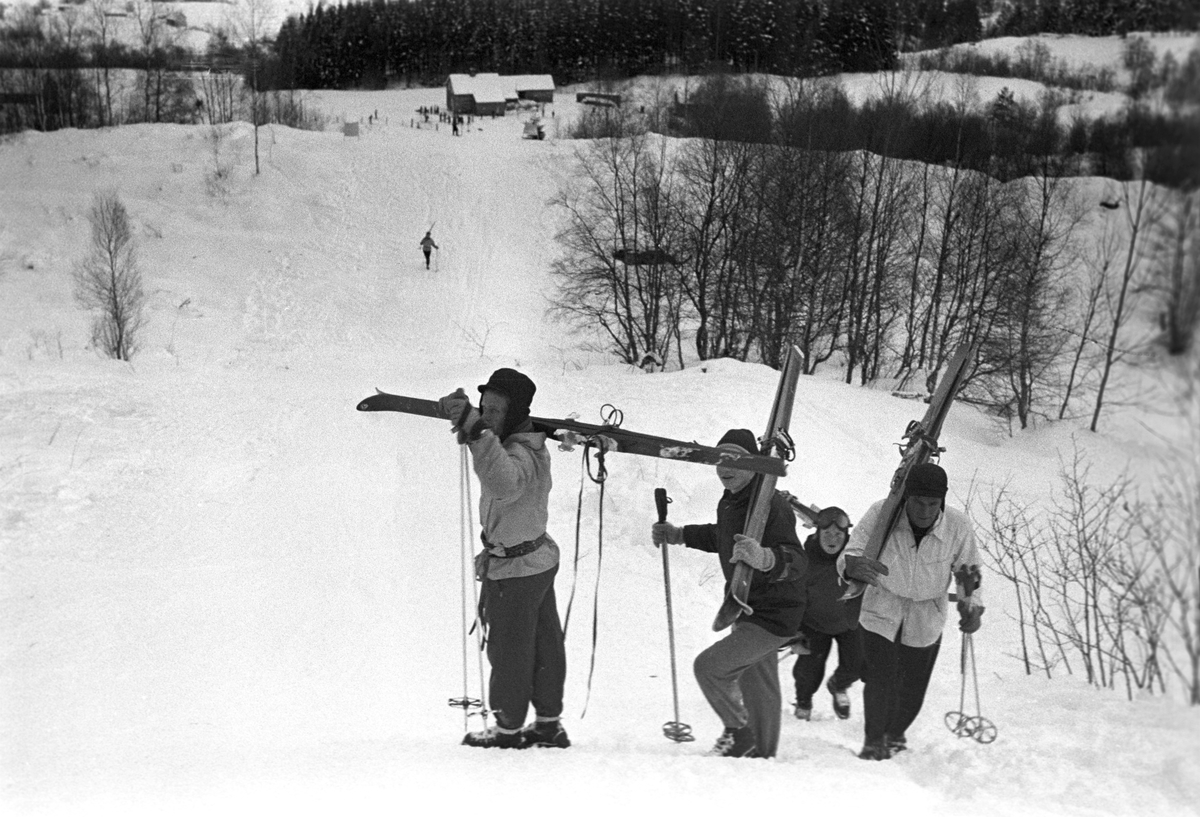 Publikum i løypa med ski på skuldrene. Holmenkollrennene på Voss 1952. Fotograf Dagbladet