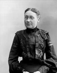 Portrett, kvinne med svart kjole og briller. Fru Jentoft Lar