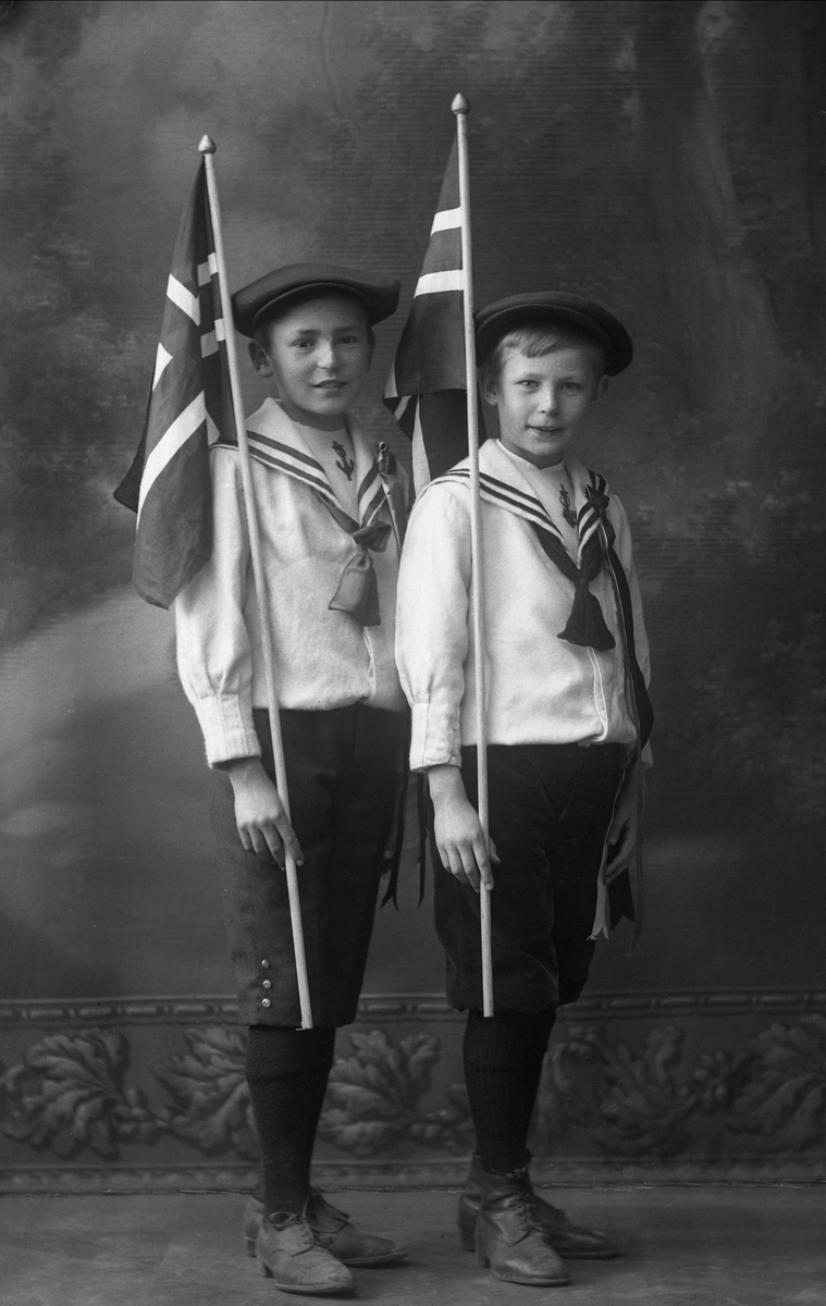 Gruppeportrett, to gutter i matrosdrakt med norske flagg og sixpence. Edgar og Nicolay Martin.