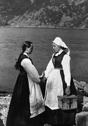 Gruppeportrett, to kvinner i hardangerbunad, med reiseskrin,