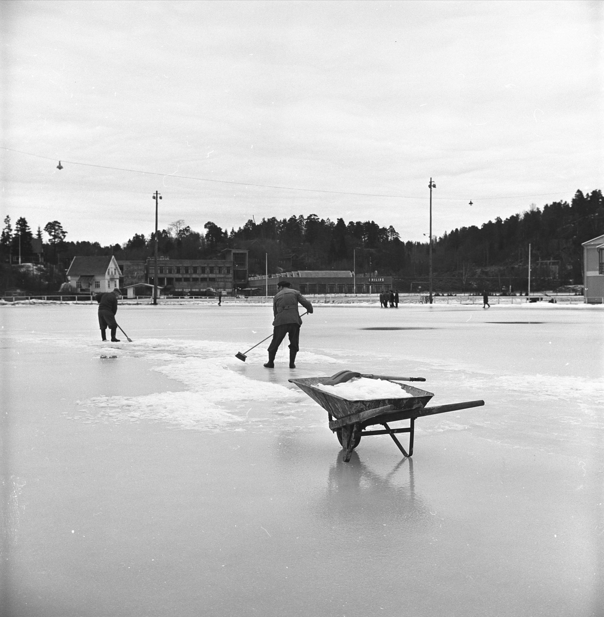Arendal. Bjønnes stadion (anlagt 1952) med snørydding. Trillebår.