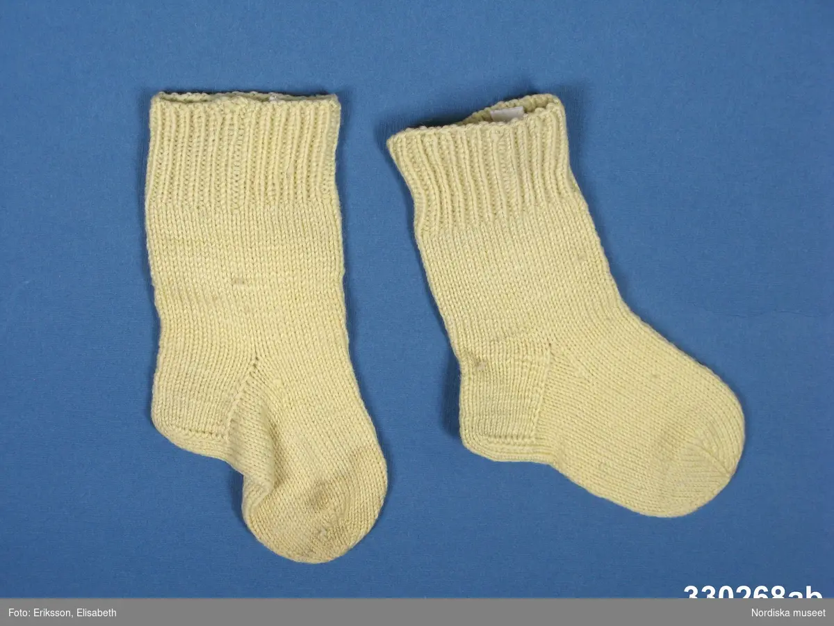 Gula stickade sockor [a-b] för ca 1-2-årig flicka. Foten slätstickad, resårstickad mudd.
Anm: I mycket gott skick.
/Zingoalla Rosenqvist 2010-04-08