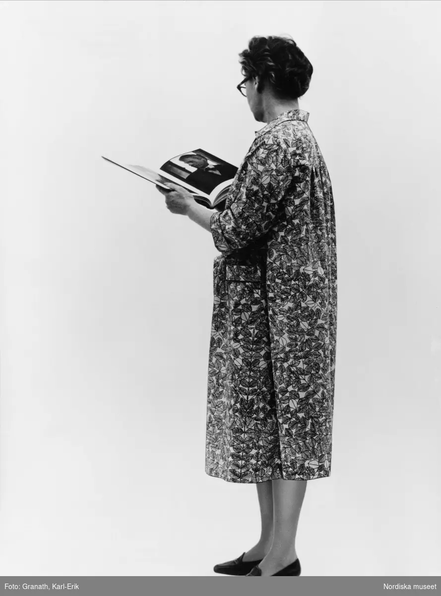Kvinna i klänning (rockklänning NM.0296919A) tittar i en bok