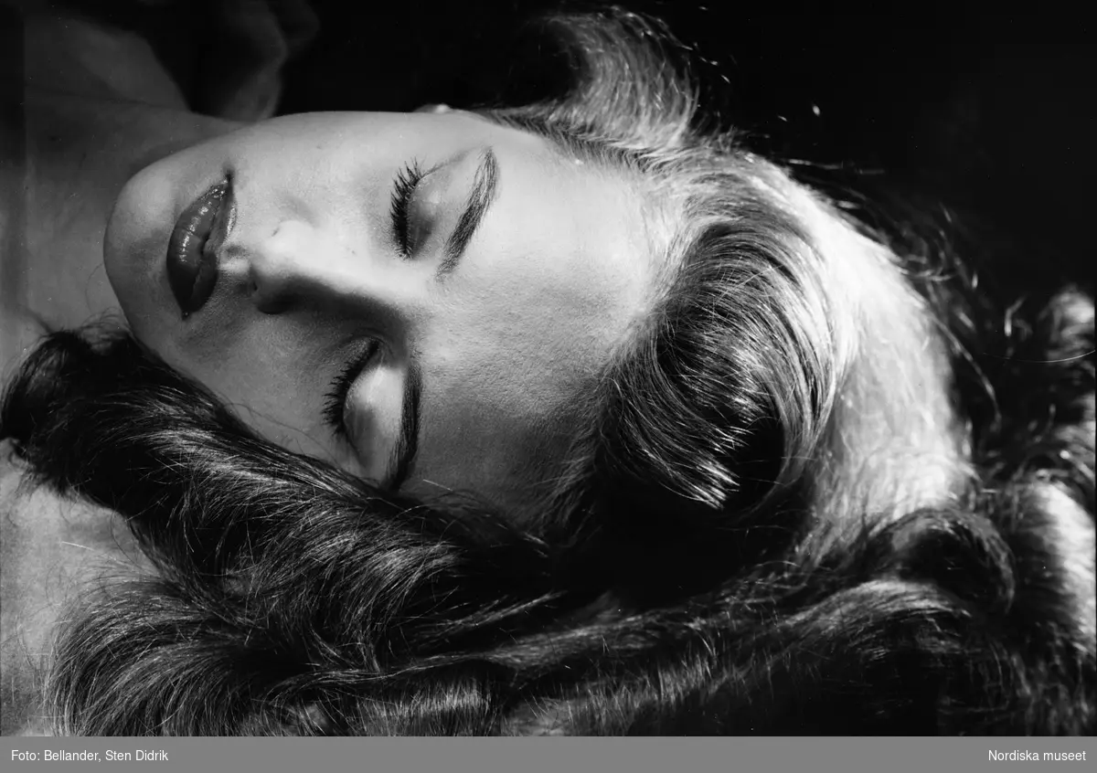 Närbild på ung kvinna som ligger ned med utslaget hår.
Studiobild.