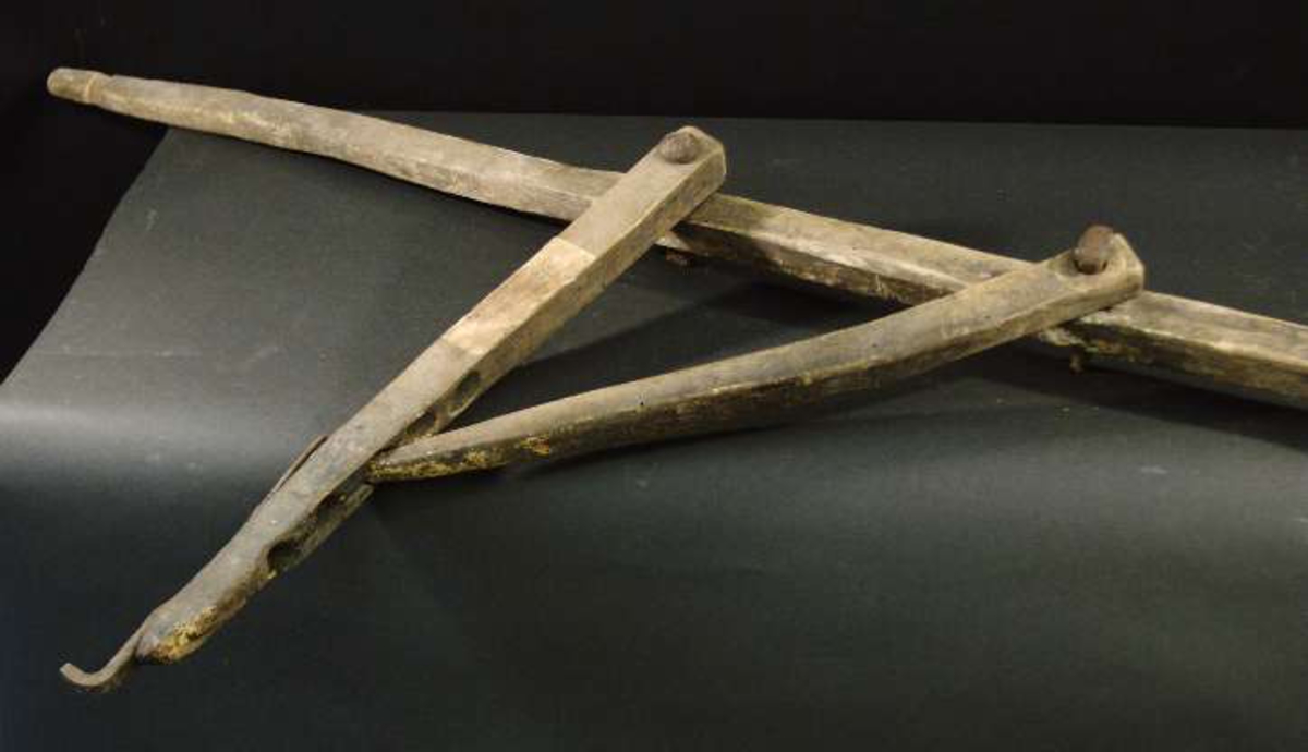 Grytståndare av trä bestående av lång trästång med två horisontella armar, den ena för att hålla upp den andra, där grytan hängdes på en järnkrok.
