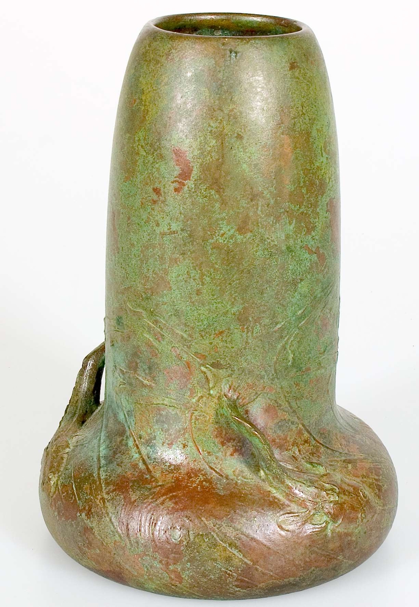Två vaser av brons. Den mindre vasen är stämplad med Hugo Elmqvists gjutarstämpel, D.6, E Kock, A otydlig text= A.B. Elmqvistska gjutmetoden. Den större vasen är av grönpatinerad brons i jugendstil med fiskar simmande i vågtoppar i relief och på skulptur runt den vulstformade nederdelen. Signerad E H. På undersidan rund gjuten stämpel och E XII.