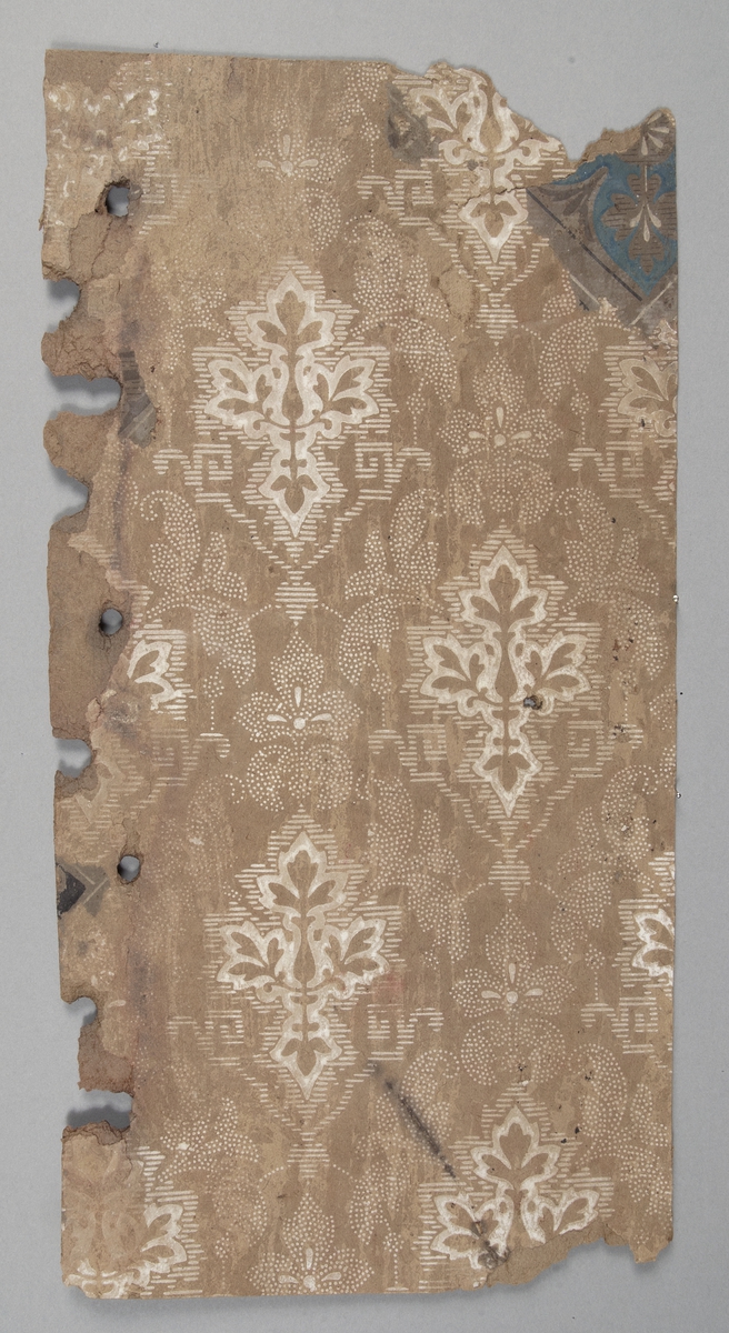 Tapetprovet (3 fragment) har ljusbrun grundfärg, med tryck i vitt.