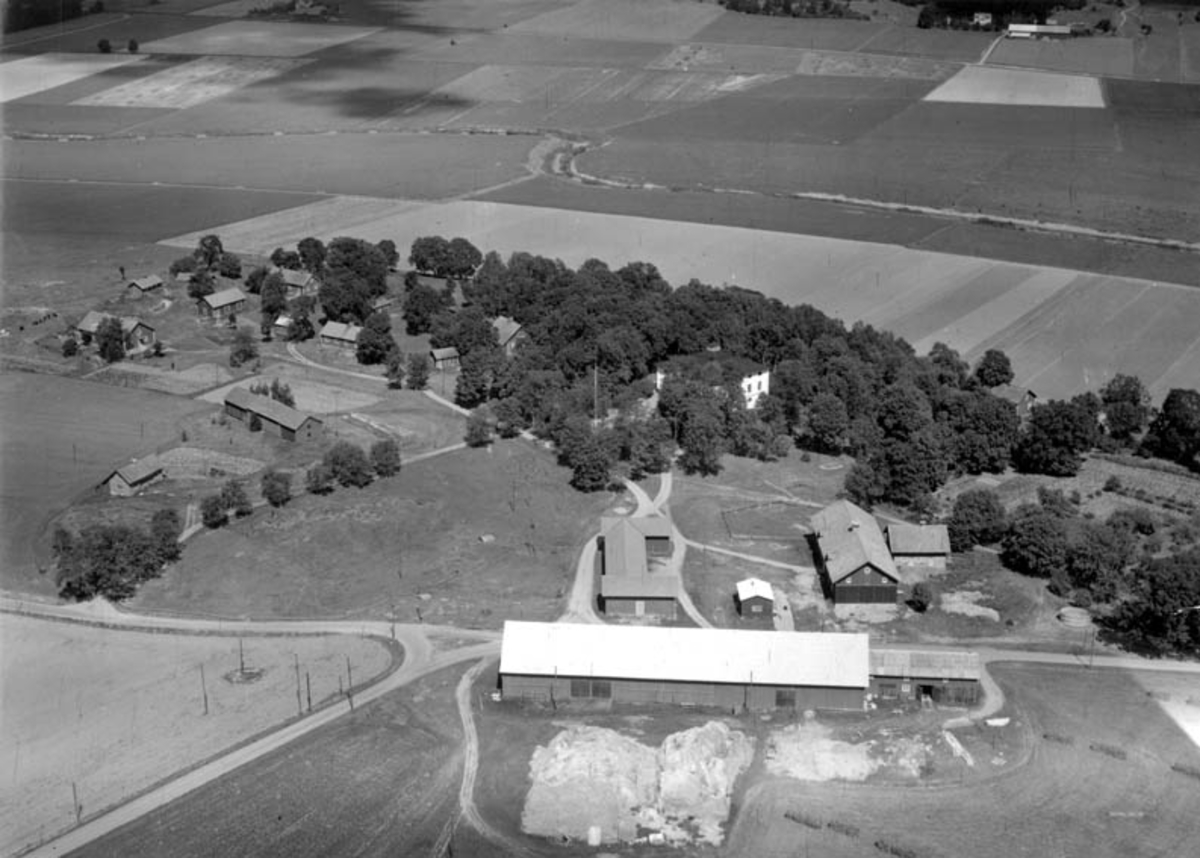 Flygfoto över Landsberga gård, Biskopskulla socken, Uppland med omgivande bebyggelse och marker 1952