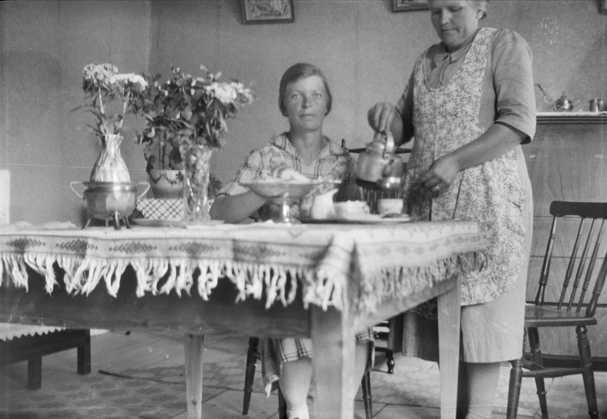 Thea Blom serverar Ebba Spång kaffe i köket på gården Ytterkvarn, Österunda socken, Uppland 1940 - 50-tal