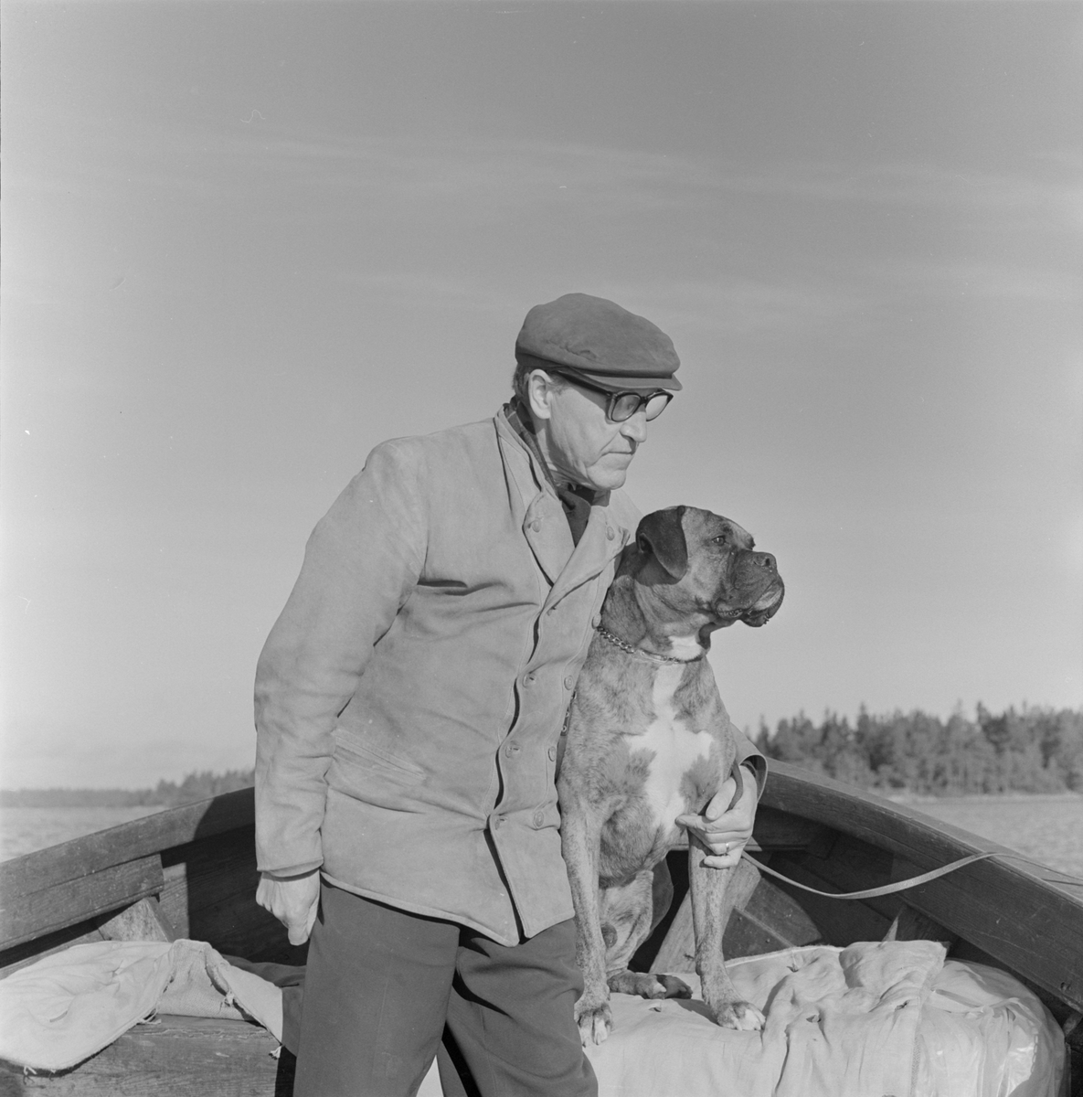 Fotograf Gunnar Sundgren med sin hund i båt, sannolikt Uppland