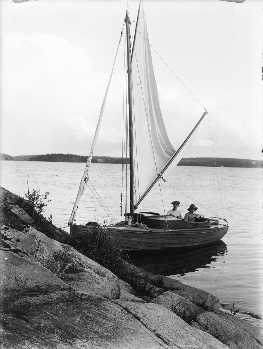 Fotograf Paul Sandberg med sin hustru Signe Margareta i segelbåt, sannolikt vid Ekolns strand, Uppland