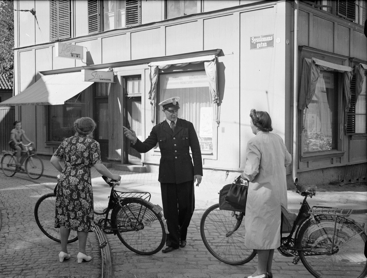 Polis talar med cyklister vid Walmstedstska gården, Sysslomansgatan, Uppsala 1949