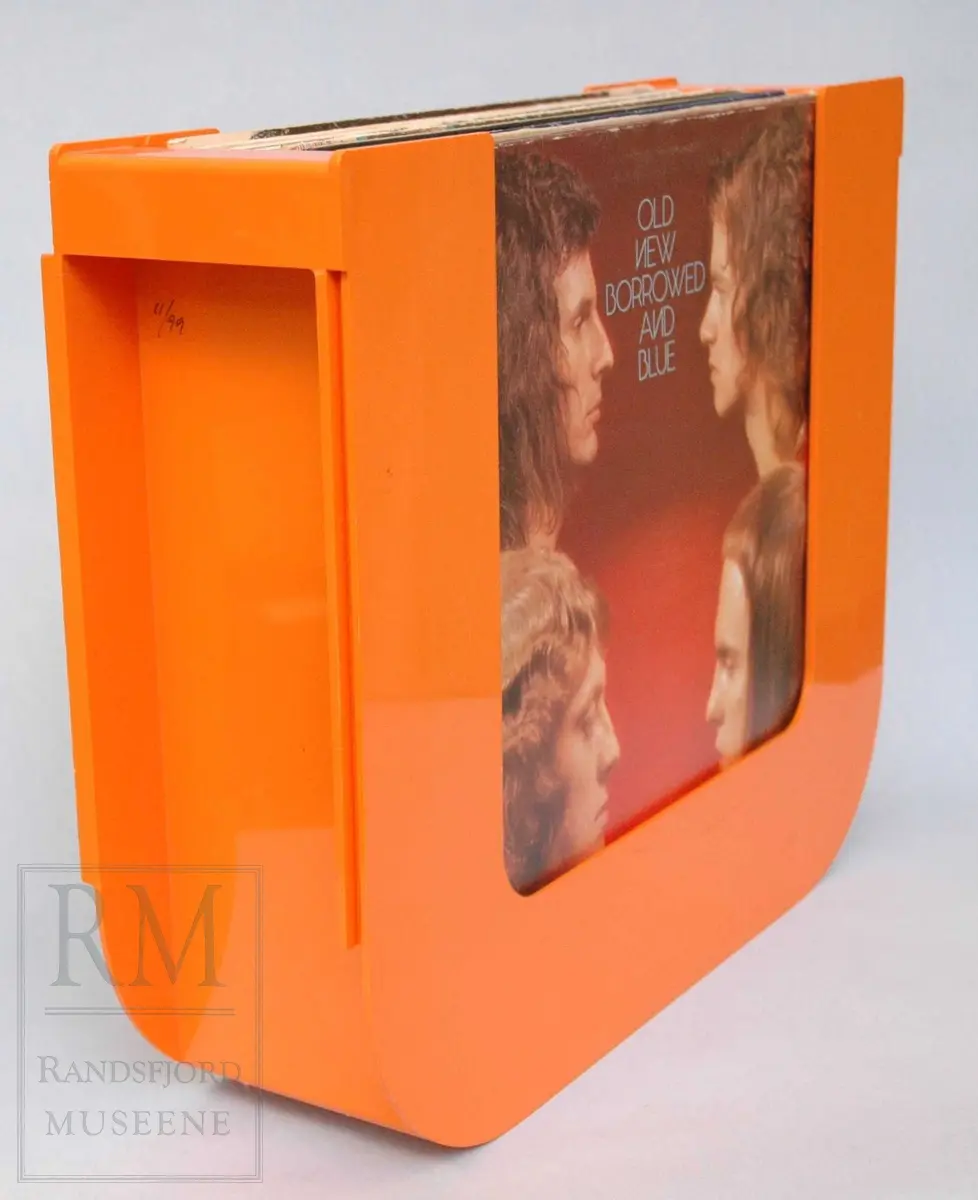 Platestativ i orange plast med plass til ca 20 LP-plater. Medfølger 17 plater.