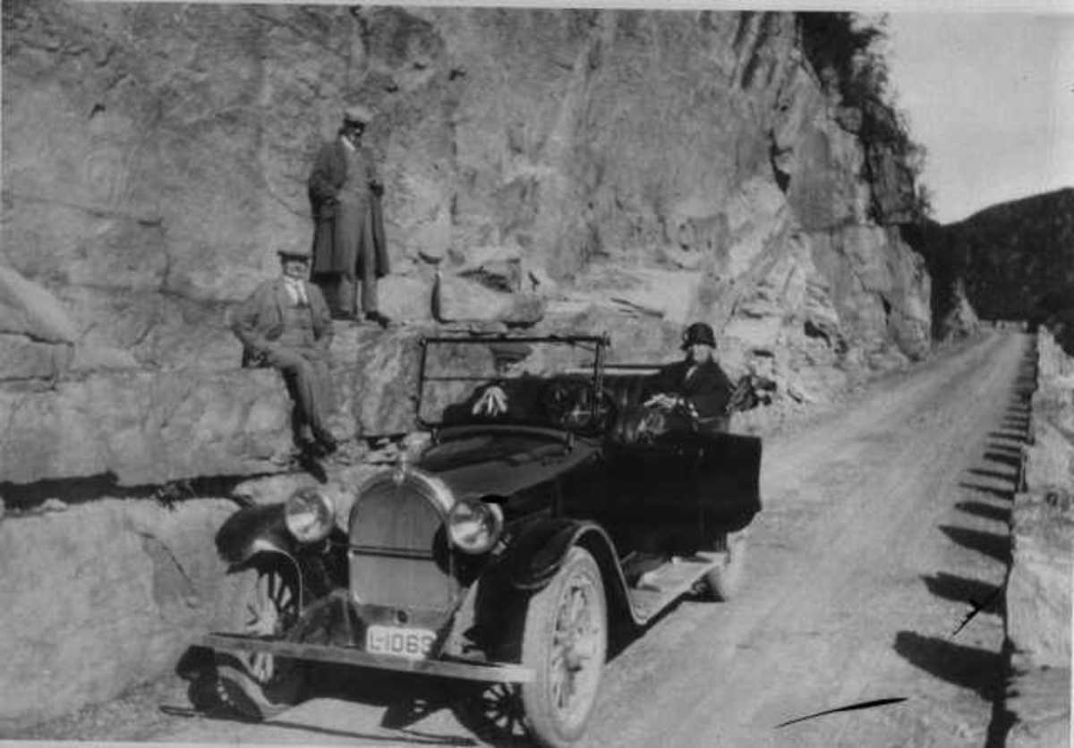 Familie Øglænd på biltur i sin Oldsmobile fra 1925: bil stanser på en vei langs en fjellvegg, Jonas Øglænd sitter i bilen