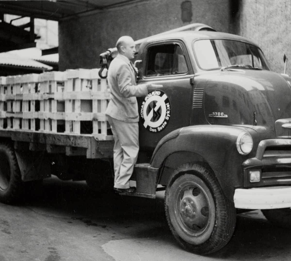 Kjell Anda snakker med sjåføren av en lastebil, merke Chevrolet 1955 COE, som er på vei ut med varer fra Jonas Øglænd, Sandnes.