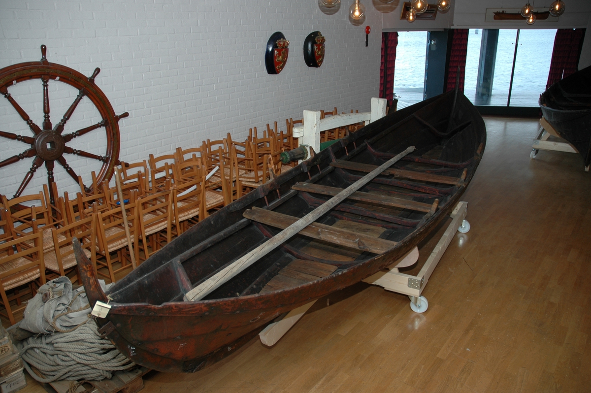 Seksring fra Masfjord Hordaland. Tjærebredd båt med tre keiper på hver side. Med tiljer.