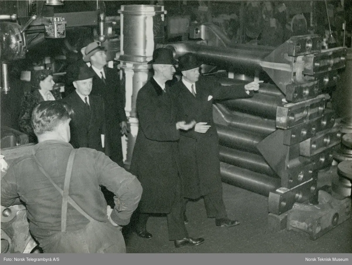 Kongefamilien på omvisning i motorverkstedet på Akers Mek. Verksted i forbindelse med stabelavløpningen av M/S Taurus, B/N 482 6. april 1948. Skipet ble levert i 1948 til Wilh. Wilhelmsen.