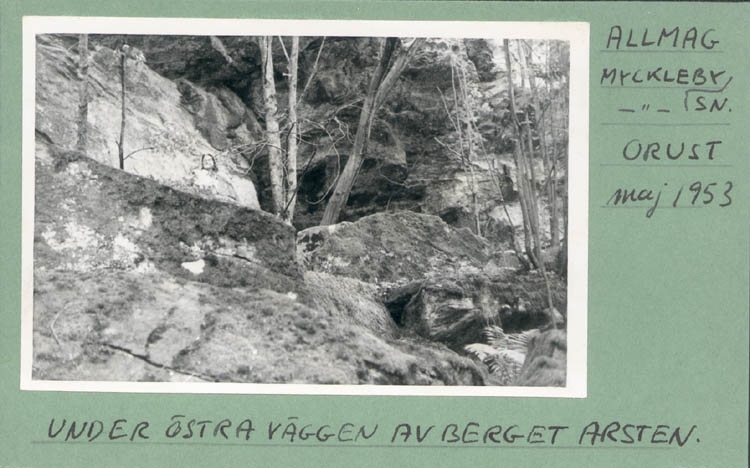 Noterat på kortet: "Allmag Myckleby Sn. Orust. Maj 1953."
"Under östra väggen av berget Arsten."