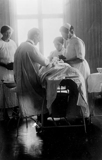 Enligt fotografens noteringar: "Läkare+sjuksköterska vid operationsbordet."