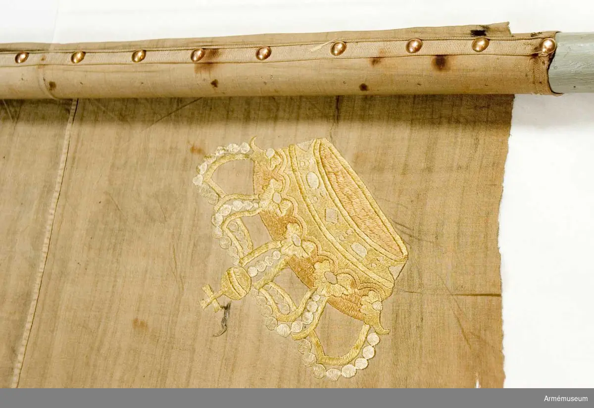 Duk: Enkel, tillverkad av vit linnelärft. Sydd av två horisontella våder. Ursprungligen kantad med kypertvävt band. Fäst vid stången med ett liknande band under en rad tennlikor.

Dekor: Broderat omvänt lika på båda sidor med gult silke i dubbelsidig plattsöm Karl XIV Johans namnchiffer, dubbelt C bildat av små ornament, inom dessa XIV krönt med sluten krona med blekt rött (?) kronfoder, i hörnen liknande kronor. 

Stång: Tillverkad av vitmålad furu.