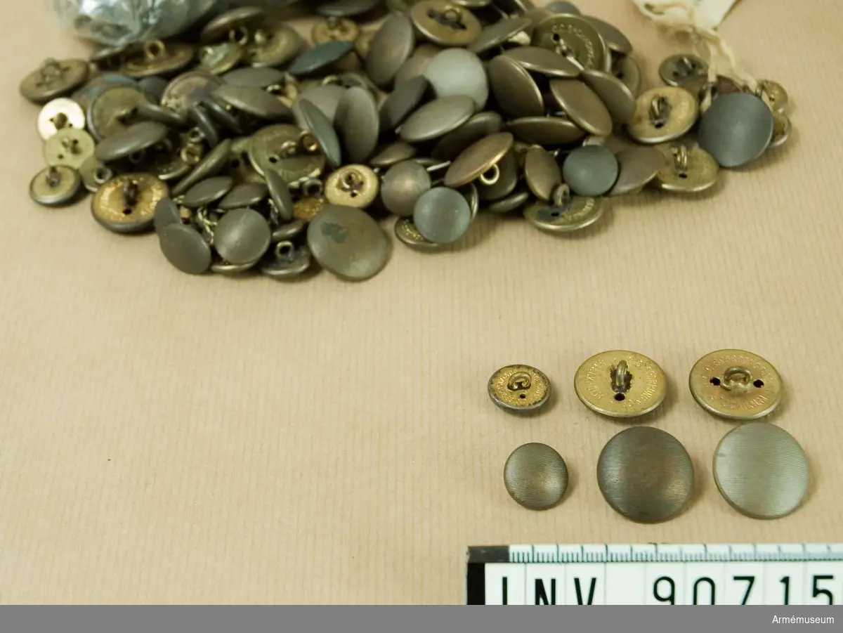 Större antal bronsfärgade, räfflade knappar. Både små och stora.