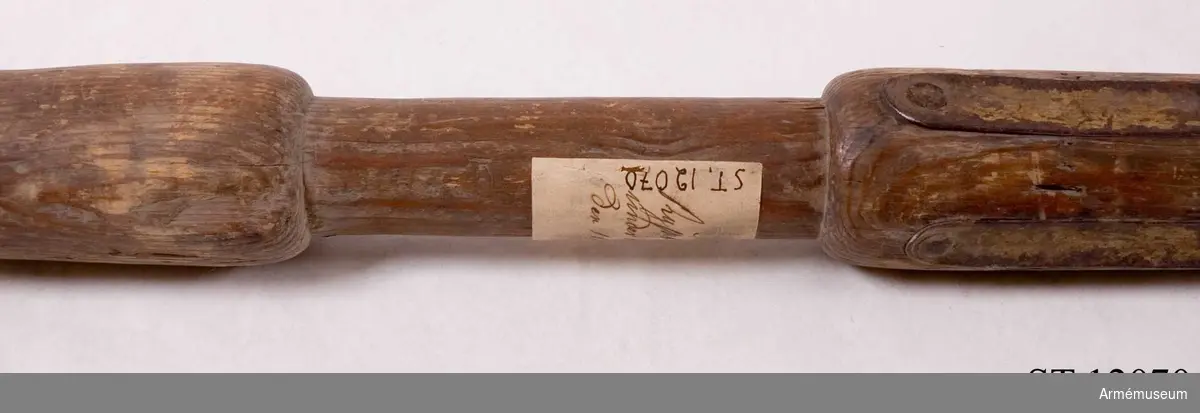 Stång av barrträ, delvis rödmålad och med förgylld beslagning. Text på etikett: "Nr 66 Ryskt standar taget under konung Johan III:s regering."