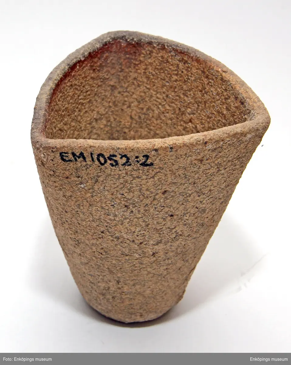 Degel av grov keramik, trekantig vid mynningen och rund nedtill.