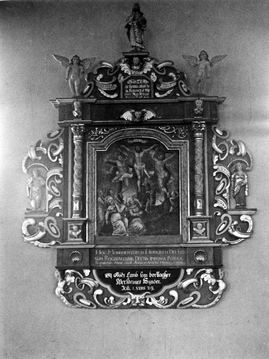 Rogberga gamla kyrkas altaruppsats. Den föreställer korsfästelsen, daterad 1668 och renoverad 1747. Tavlan är en detaljkopia av en altartavla i Linöpings domkyrka. Mästaren till denna är M. van Heemskerk.