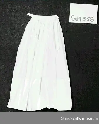 Sorgförkläde i vitt linne med band. Förklädet har burits av fru Johanna Eklund, född 1888 i Sundsvall.