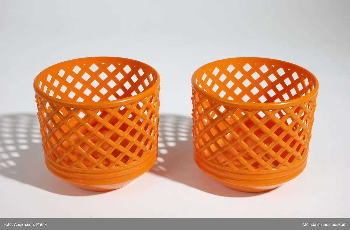 2 st blomkrukor. De är orange och har ett flätat/håligt mönster. Båda är lika stora.Mått på en blomkrukaHöjd: 100 mm, Diam: 110 mmGivaren Kerstin Olofsson använde dessa under 1970-talet.