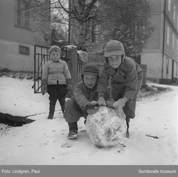 Första snön. På bild 1 ses Bo Westerlund med bror rulla en snöboll. Snickaregatan 11 och 13.
