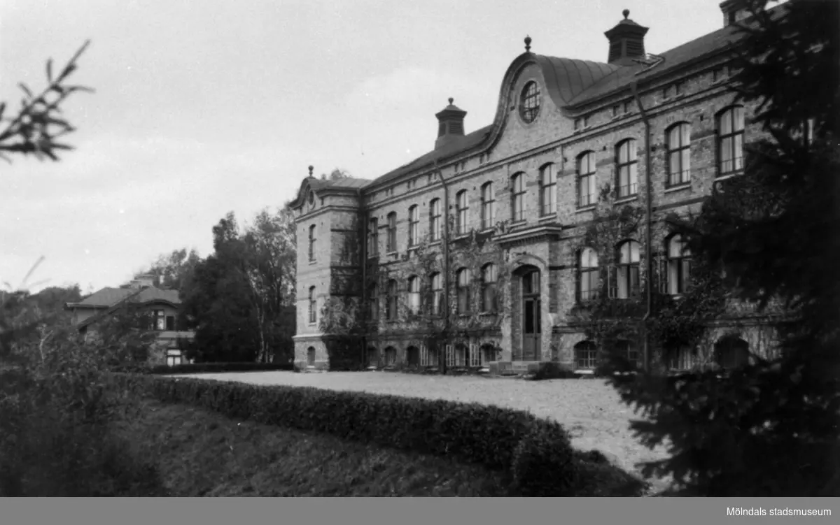 Stora skolan vid Stretereds skolhem, tidigt 1930-tal. Tidig bild med vindsplanet i det äldre utförandet innan branden 1944 och med murgrönan på fasaden. Direktörsvillan som ses i bakgrunden har den äldre fasadbeklädnaden.