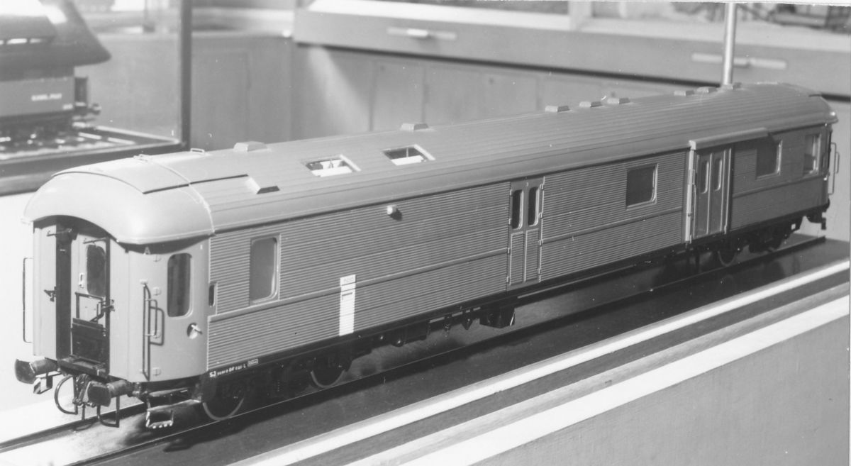 Modell av järnvägspostvagn, typ DFo 28 med avlyftbart tak.  Invändigt sittplatser, hyllor, bänkar, sorteringsbord och sorteringsfack samt postpåsar. Dessutom invändig belysning. Skala 1:20.