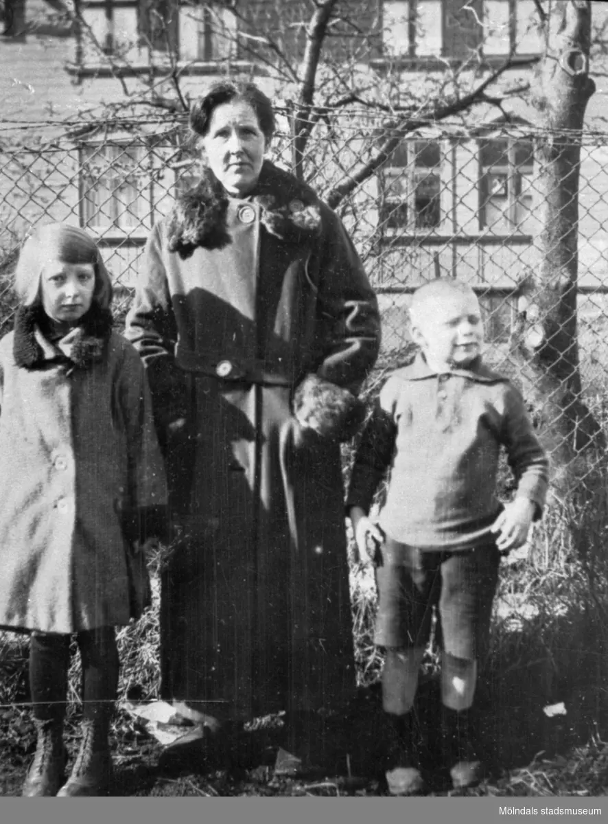 Tilda Bengtsson, med barnen Gullan och Putte, utanför "Bracka" (huset Nordängen 1 i Krokslätt) under 1920-tal. "Bracka" kallades ofta ett bostadshus för arbetare, som låg i anslutning till en industri.