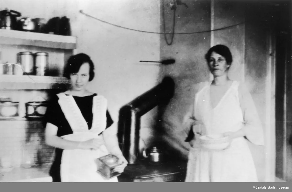 Interiör från ett arbetarhem i början av 1900-talet. Två kvinnor i ett kök. Anderstorps fabriker i Lindome.