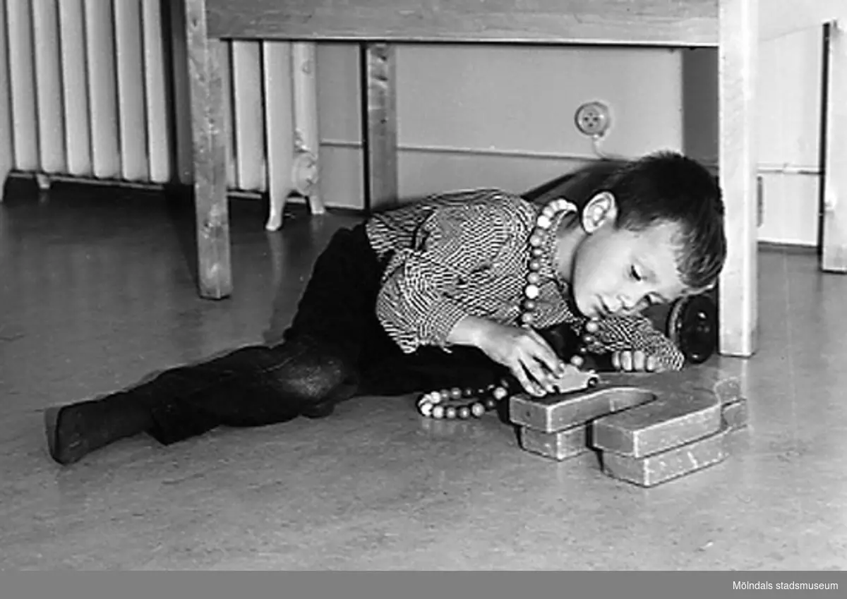 En pojke som leker på golvet med byggklossar vid Holtermanska daghemmet 1953.