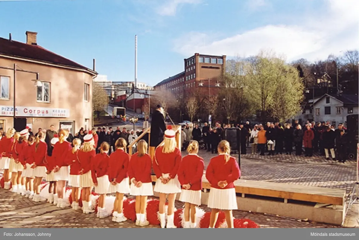 Gamla torget i Mölndal den 22:a november 2001. Folk lyssnar till tal som hålls av Lars Gahrn och Mölndals paradorkester underhåller.
Invigning efter omläggning och stenläggning av torget. I bakgrunden ses den röda höga byggnaden Stora Götafors.
