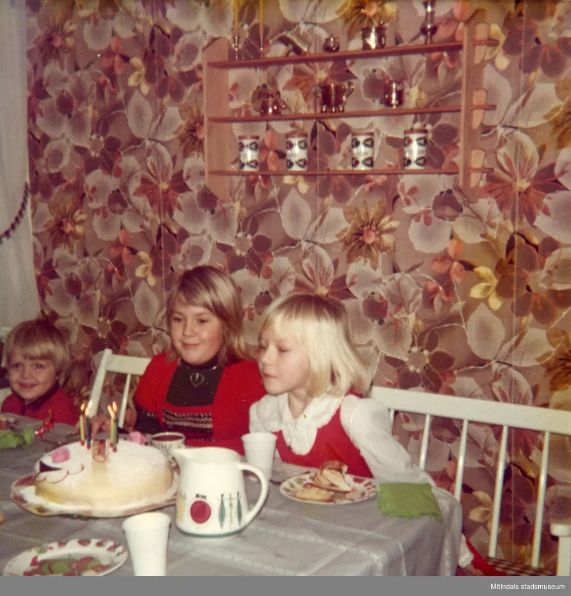Kusin Maria, syster Ingela och Christine.

Christine som fyller 6 år har födelsedagskalas i köket på Delbancogatan i Mölndal, 1977.