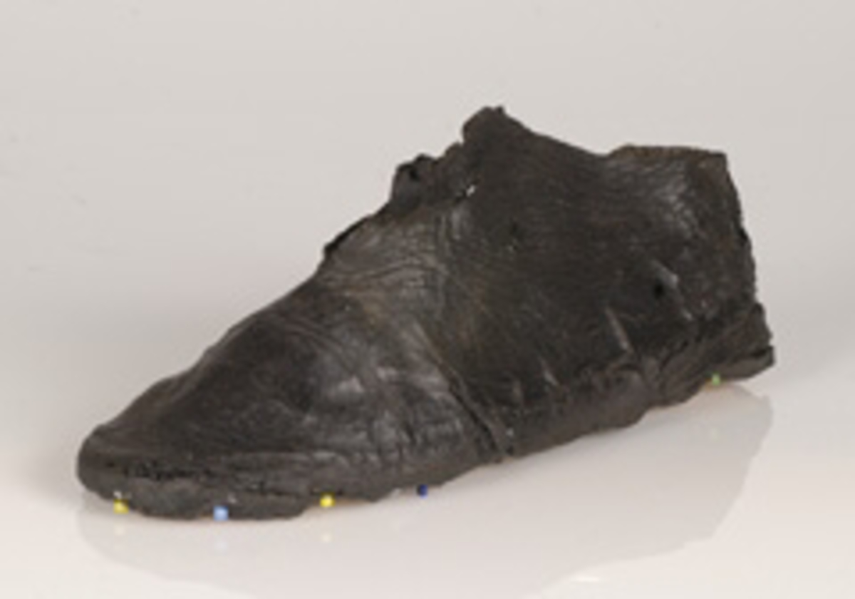 Monterad sko i form av en skoöverdel, troligtvis till en vändsydd barnsko. Med stor sannolikhet daterar sig skon till tiden före förlisningen 1628, eventuellt 1500-tal.
Skons överdel är skuren i ett stycke. Skoöverdelen har, med hjälp av en rektangulär skarvbit omslutit hela foten. Skarvbiten, som nu saknas, har suttit fästad på sidan av skon. På skons ovansidan, mot vristen, finns en något triangelformad, spetsig öppning. Över öppningen löper det en smal rem. Remmen har suttit fästad på det nu saknade sidostycket. Remmen har förts genom en skåra lädret, vikts över vristen och sedan fästs i skåror i lädret på skons motsatta sidan. Skobottnen saknas. Skoöverdelen sitter fästad på en träbotten och överdelens nedre kanter har förstärkts emd svart kartong av konserveringsenheten.
Lädret tycks vara relativt välbevarat.