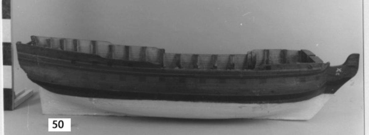 Fartygsmodell 40-kanonfregatt efter 1765 års reglemente. Skrovmodell. Bordläggningen limmad på gavlar, utan inredning, galjon och akterspegel. Modellen brunmålad med svarta kanonportar och under vattenlinjen vitmålad.