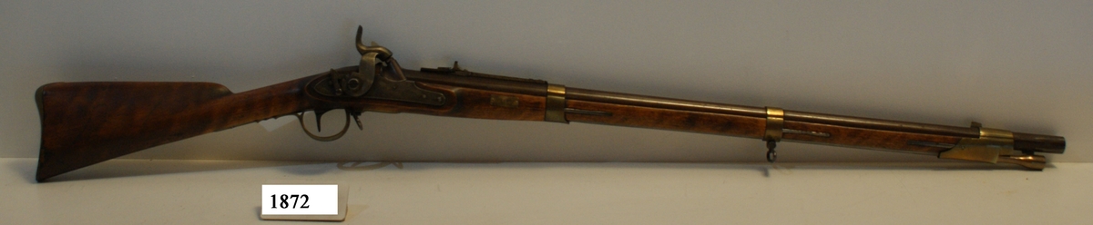 Gevär, 1815 - 1845 - 1848 års reparationsmodell, s.k. tappgevär, slaglås (Tischgevär). Märkt: Tre kronor. Kolven av trä, pipa och mekanism av stål. Beslagen av metall. Pipan räfflad.