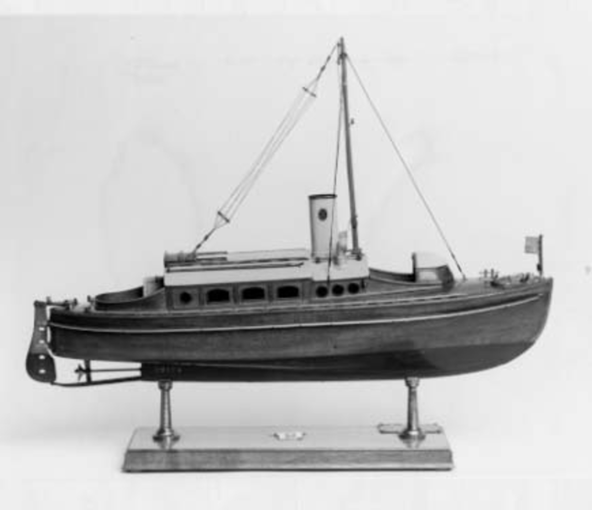 Modell av Borgila IV  som i original konstruerades av R. Östlund och var 9,1 m lång och 2,04 m bred.
Modellen har standert i masttoppen och flagga i fören, liksom ankare på fördäck.