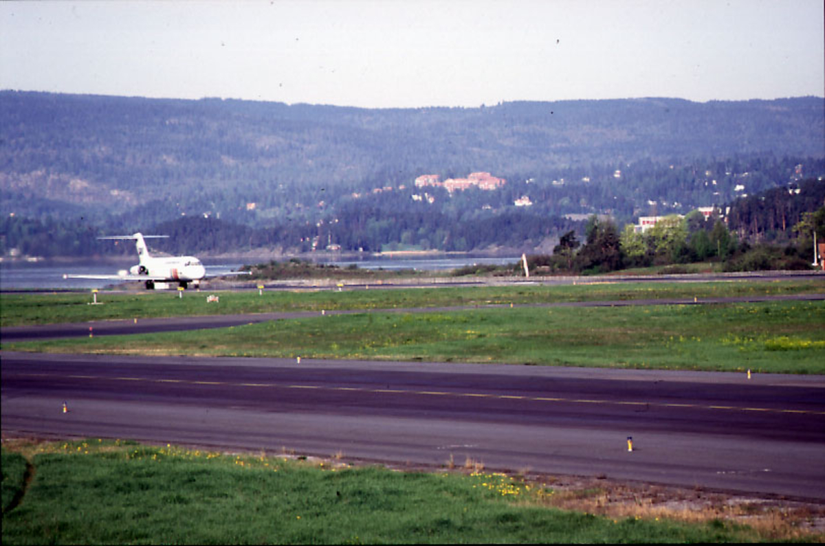Lufthavn, 1 fly på bakken, DC-9-21, OY-KGF "Rolf Viking" fra SAS.  Står ved enden av rullebanen, klar til takeoff.
