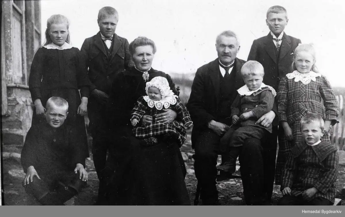 Lars og Kari Eikre med 8 av dei 10 borna  Framme frå venster Ola: (1914), Kari med Margit (1923), Lars med Per (1921), Gunhild (1916), og Lars født (1918),  Bak frå venstre: Guro (1912), Svein (1910) og Rasmus (1909).