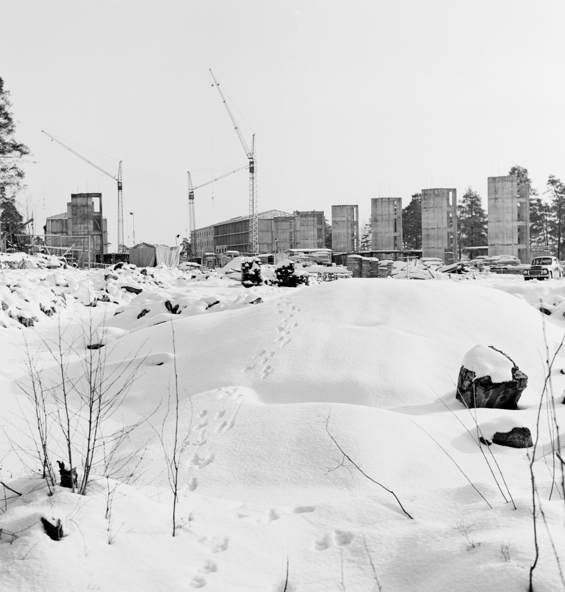 Byggarbetsplats
Exteriör, byggnader under uppförande i fonden. Öppet fält under snötacke i förgrunden.