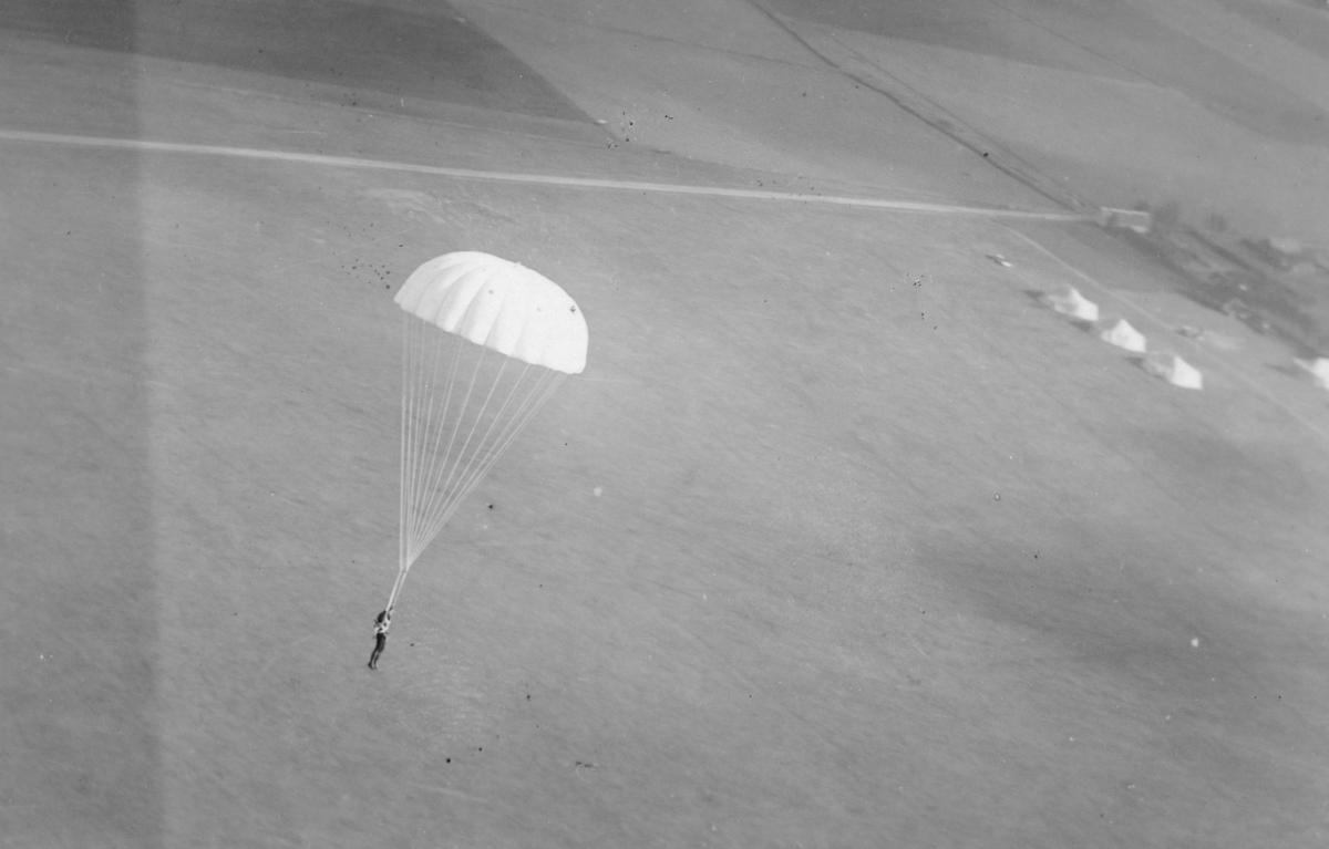 Fallskärmshoppare över flygfält, 1930-tal.