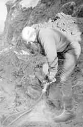 Arbeider borer hull til dynamitt i forbindelse med veibyggin